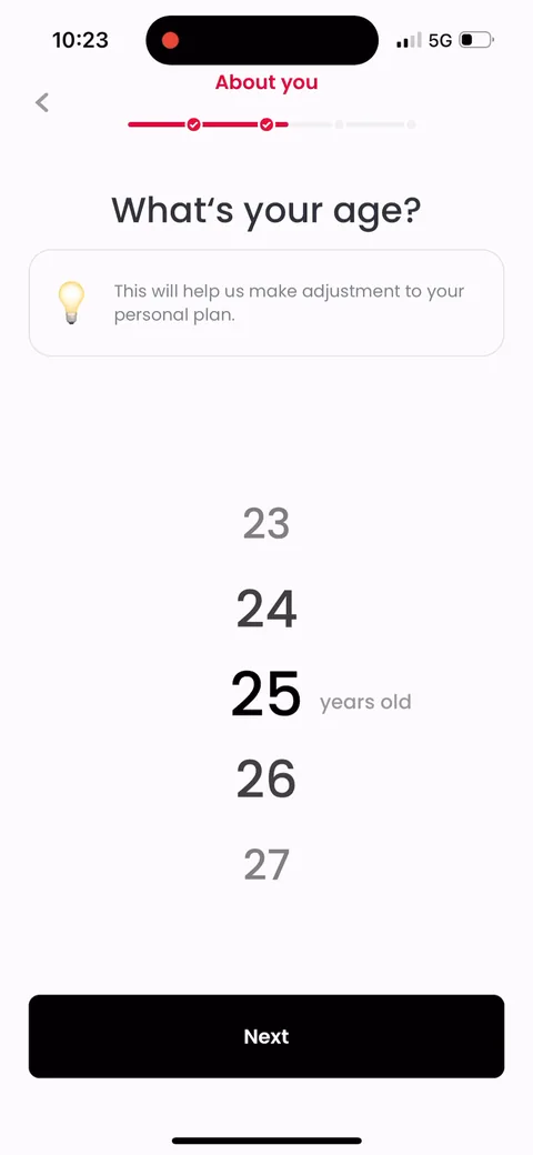 Justfit onboarding screen 22: Age, framed as 'help us make adjustments to your personal plan.' Same move as gender: every question is tied…